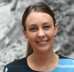 Headshot of Nicole Watson, smiling on a grey background